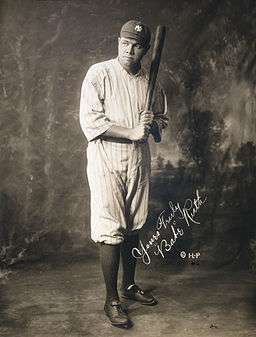 Studio photograph of a man is in uniform, posing with a bat held as if about to strike. The picture is autographed "Yours Truly, Babe Ruth".