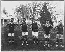 five young men in basketball uniforms with swastika logo