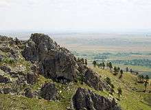 Photograph of the rocky summit of Bear Butte and the view over the Dakota plains.