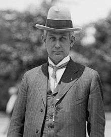 A black and white photo of a man in a suit and hat