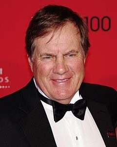 Color head-and-shoulders photograph of Bill Belichick wearing a black tuxedo and black tie.