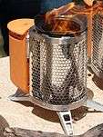 A photo of a BioLite CampStove in operation being demonstrated outdoors