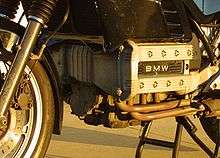 Closeup picture of BMW K100 engine. Also shows some black bodywork, forks and a front brake calliper