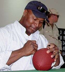 A picture of Bo Jackson signing a football.