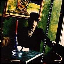 A photograph of Dylan seated at a table wearing a top hat and tuxedo