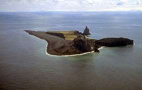 Aerial view of irregularly-shaped island with prominent rocky outcroppings