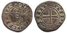 An old coin depicting a head on one side and a cross on the other side