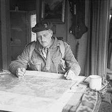 Man sitting at a table looking down at a map