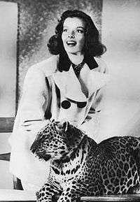 Katharine Hepburn, smiling, and leopard looking off-camera