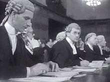 Six members of the British legal team seated at a table.