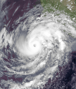 A visible satellite image of an intensifying Category 2 hurricane with a clear eye.