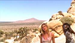 Two women standing in a desert landscape.