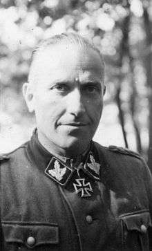Black-and-white portrait of a man wearing a military uniform with an Iron Cross displayed at his neck.