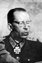 Black-and-white portrait of a balding older man wearing a military uniform with an Iron Cross displayed at his neck.