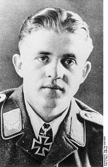 A man wearing a military uniform with an Iron Cross displayed at his neck.