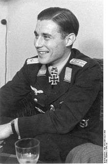 Prince Zur Lippe-Weißenfeld is casually sitting and smiling. The Knight's Cross of the Iron Cross, German Cross in Gold and Pilots Badge can be seen on his uniform.