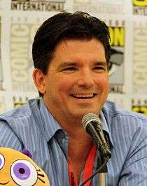 Butch Hartman, at the 2009 Comic Con in San Diego, sitting at the panel and smiling.