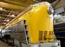 A yellow, streamlined steam locomotive.
