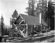 Photo of men working to construct a cabin