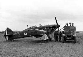 Single-engined military monoplane being refuelled by truck on airfield