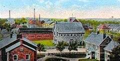 alt=Postcard of the Calumet and Hecla company town, showing multiple buildings.