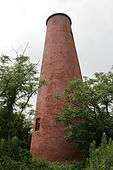 A shorter, conical reddish lighthouse