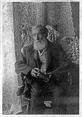 Black-and-white photo of an old man with a long white beard
