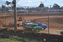 cars racing on a dirt track