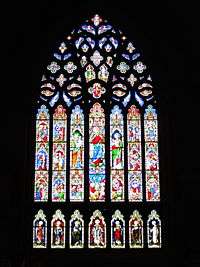 An elaborate, tall and wide stained glass window depicting the life of the Virgin Mary