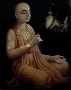 A painting of a man with shaved head and dressed in saffron robes sitting cross-legged