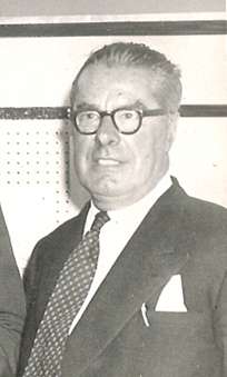 Charles Cooper, bespectacled and with grey hair, in his late 60s, wearing a dark suit and tie.