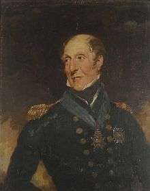 Half-length portrait of a man looking over his shoulder. His hair is sparse and balding, and he wears a dark blue jacket with epaulettes and gold buttons, with a blue sash collar around his neck, suspended from which is a medal.