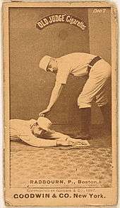 A picture depicting a baseball player who is holding a ball that tagging out another baseball player who attempting to reach base