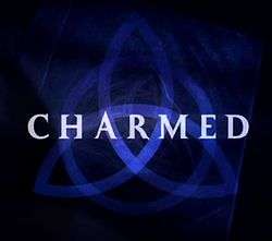 A dark blue triquetra over a darker blue background that fades to black near the edges with the word charmed in capital letters across the center using a light-blue, medium-sized font