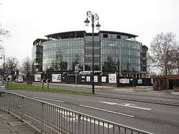 A photograph of a circular glass building with six storeys
