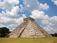 A large nine-storied stone pyramid with smoothed surfaces and stairs leading to the top from at least two sides. At the top of the pyramid there is a square structure with flat roof and entrances from both visible sides.