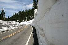 SR 410, east of Tipsoo Lake, approaches Chinook Pass, which serves as the border between Pierce and Yakima counties and between the Mount Rainier National Park and Wenatchee National Forest, in June when snow levels are still high and snow plows still are in use.