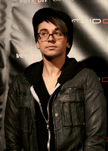 A man wearing glasses and a black shirt and jacket