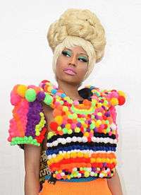 Nicki Minaj in a colorful dress looking towards her left
