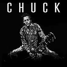 A black-and-white digital image of Berry holding a guitar toward the camera with "CHUCK" written in white on a black background