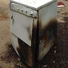 A photo of a clothes dryer that has been damaged by fire.