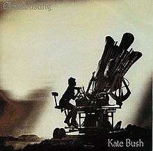 cover of Kate Bush's single, showing her sitting astride a reproduction of a 'cloudbuster'