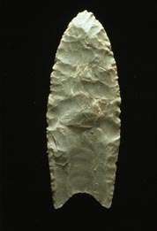 A Clovis blade with medium to large lanceolate spear-knife points. Side is parallel to convex and exhibit careful pressure flaking along the blade edge. The broadest area is near the midsection or toward the base. The Base is distinctly concave with a characteristic flute or channel flake removed from one or, more commonly, both surfaces of the blade.  The lower edges of the blade and base is ground to dull edges for hafting. Clovis points also tend to be thicker than the typically thin latter stage Folsom points. Length: 4–20 cm/1.5–8 in. Width: 2.5–5 cm/1–2
