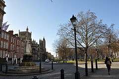 view College Green showing Queen Victoria statue, Cathedral and Council House, with restored cast iron lamp post in foreground