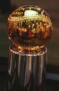 A golden baseball resting atop a silver pedestal