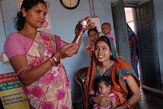 A community health worker prepares a vaccine.