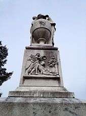 An image of a relief on the monument's top block representing either Fame or an angel placing a laurel wreath upon the head of a dying soldier clasping his sword