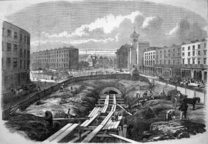 Etching, showing a large, deep cutting taking up width of the road. The excavation is filled with scaffolding and the partially completed and covered-over tunnel is beyond