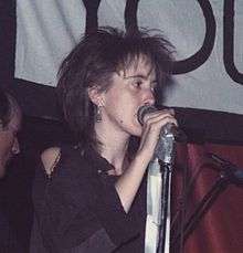 Thin young female singer with punk haircut