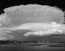 A black-and-white photograph of an unusual cloud formation over Crater Lake in Oregon.